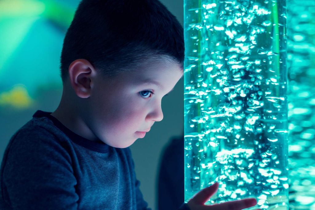 enfant avec front posé sur un tube à bulles turquoise