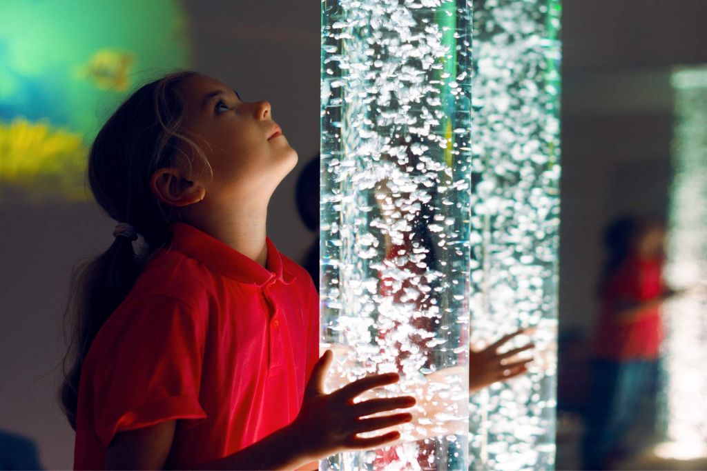 enfant qui regarde un tube à bulles